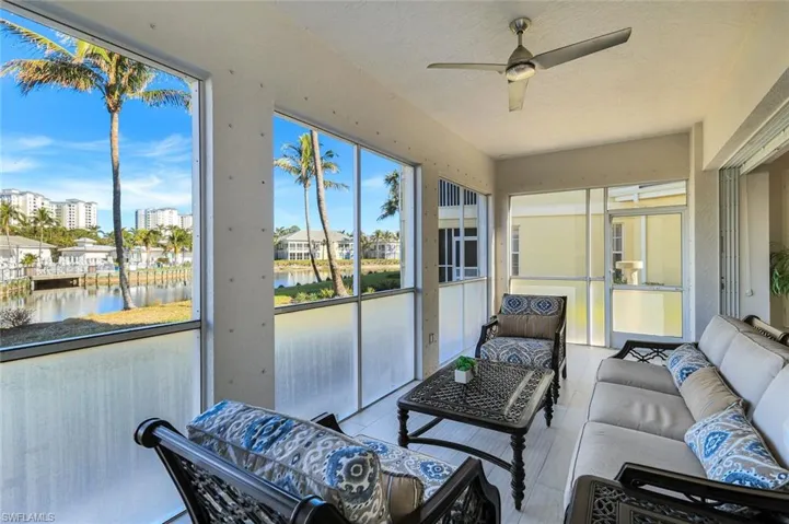 Sunroom featuring a water view and a textured ceiling