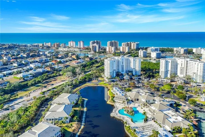 Aerial view of property and surrounding area with a nearby body of water and nearby urban area