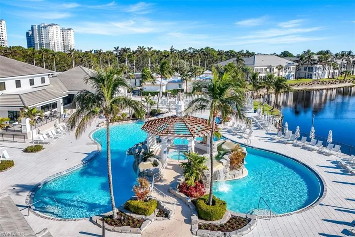 Community pool with a patio area and view of scattered trees
