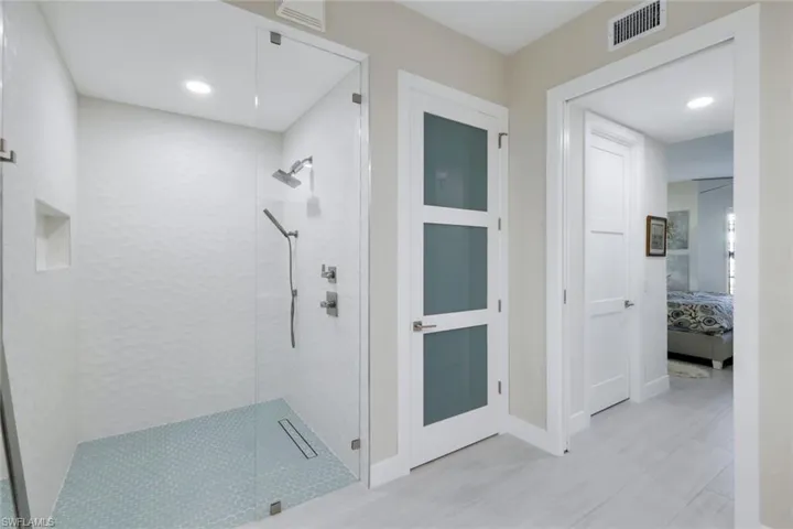 Full bath with a shower stall, connected bathroom, and recessed lighting