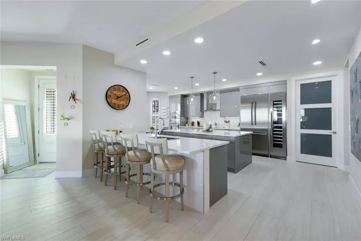 Kitchen with a kitchen breakfast bar, gray cabinets, modern cabinets, pendant lighting, and recessed lighting