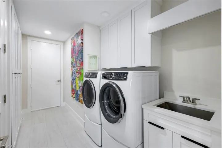 Laundry room featuring cabinet space, washer and dryer, and recessed lighting