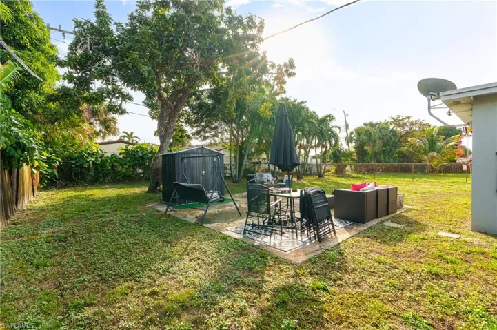 Fenced backyard featuring a patio, a shed, and outdoor lounge area