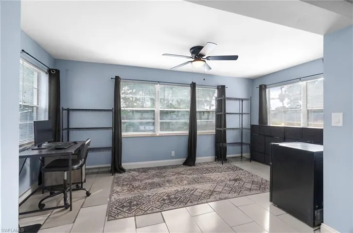 Home office with plenty of natural light, a ceiling fan, and light tile patterned flooring
