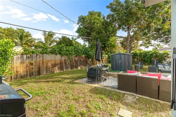 Fenced backyard featuring an outdoor living space, a patio area, and a shed