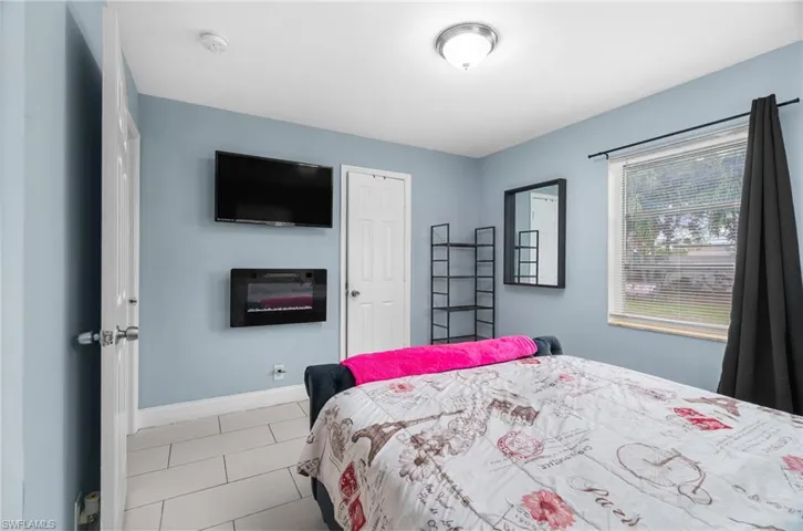 Tiled bedroom featuring baseboards