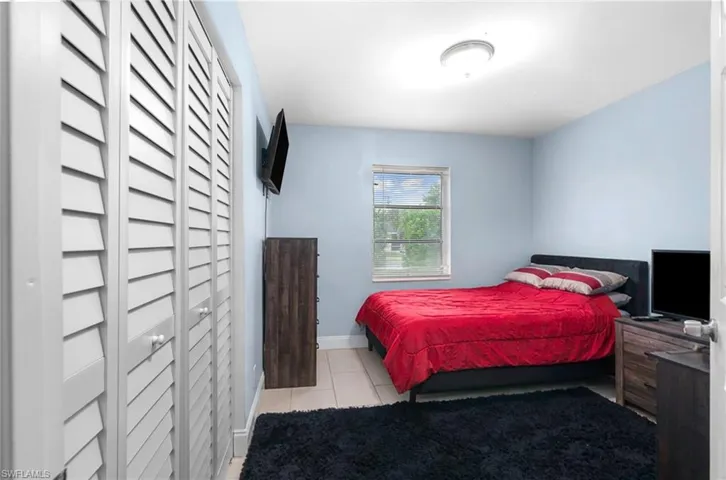 Bedroom with light tile patterned floors and baseboards