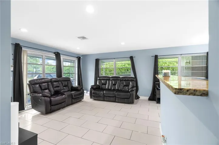 Living room with plenty of natural light, recessed lighting, and light tile patterned flooring
