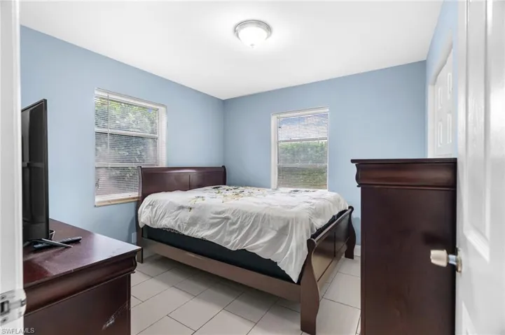 Bedroom featuring multiple windows and light tile patterned floors