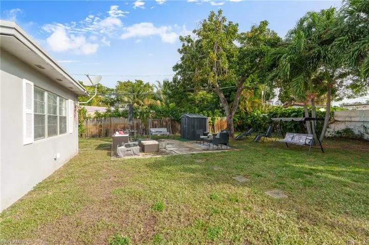 Fenced backyard with a patio and a storage unit