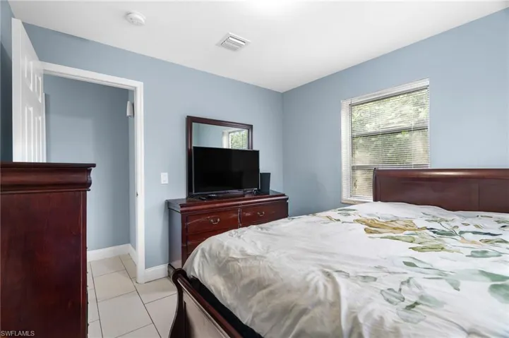 Bedroom with light tile patterned flooring and baseboards