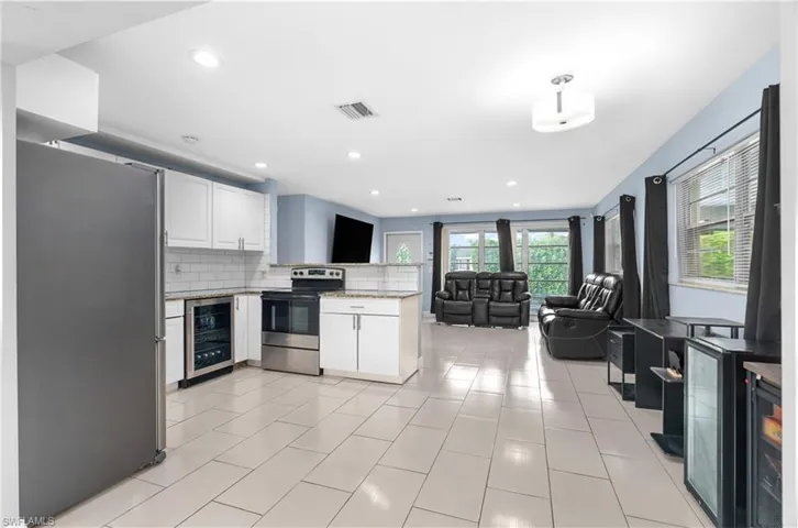 Kitchen with white cabinets, a peninsula, open floor plan, appliances with stainless steel finishes, and recessed lighting