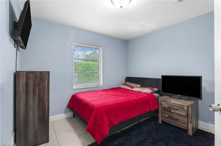 Tiled bedroom featuring baseboards