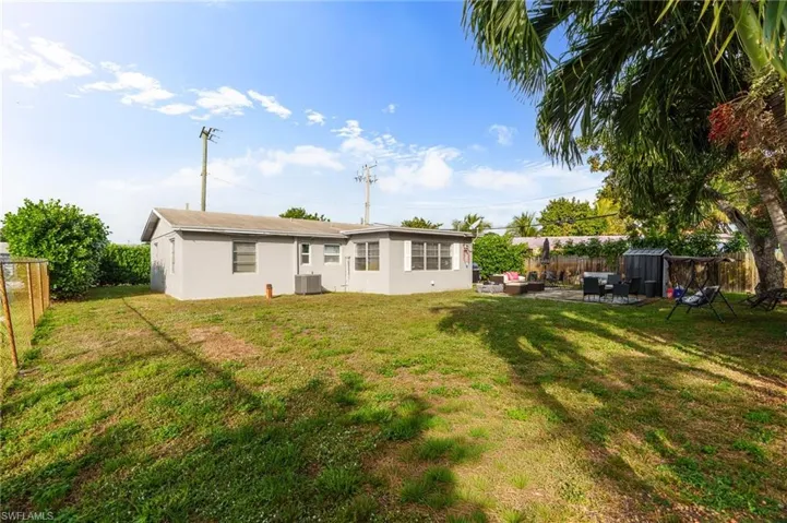 Back of house with a fenced backyard, outdoor lounge area, stucco siding, a patio, and a storage shed