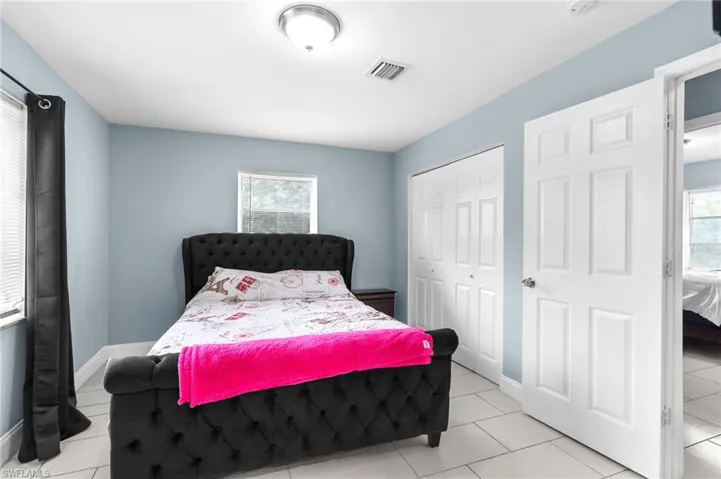 Bedroom with a closet and light tile patterned floors