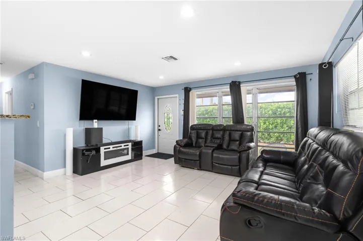 Living area featuring recessed lighting and light tile patterned floors