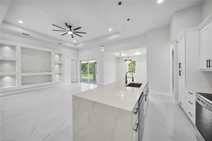Kitchen with recessed lighting, a sink, stainless steel appliances, built in features, and marble finish floor