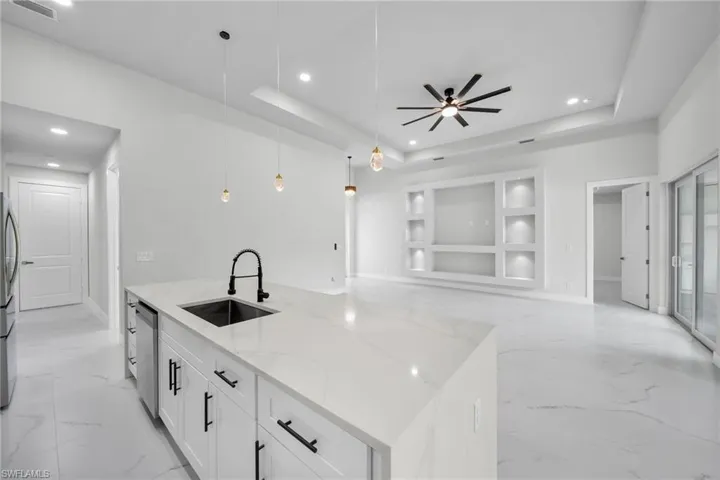 Kitchen featuring appliances with stainless steel finishes, open floor plan, recessed lighting, and a sink