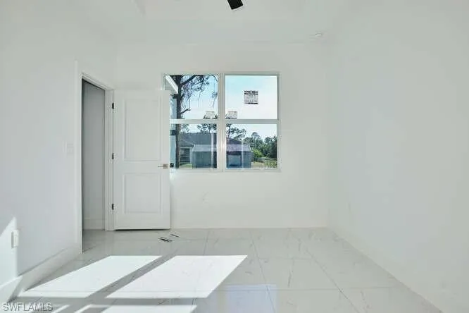 Spare room featuring light marble finish flooring and ceiling fan