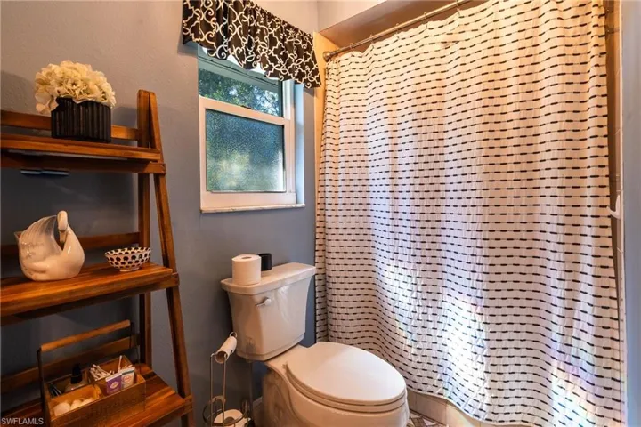 Bathroom with toilet and curtained shower
