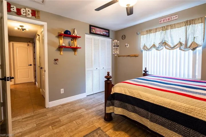 Bedroom featuring wood-type flooring, ceiling fan, and a closet