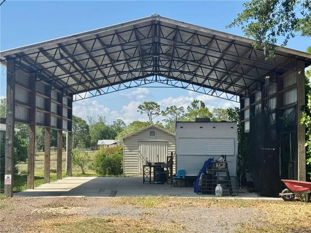 View of parking with a storage shed and a carport