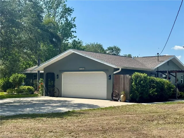 Single story home featuring concrete driveway and a garage