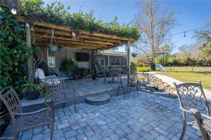View of patio featuring a playground and a sunroom