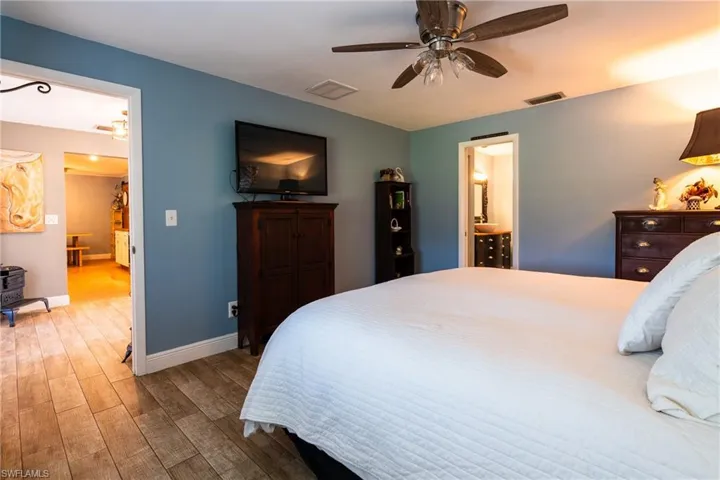 Bedroom featuring ceiling fan and connected bathroom