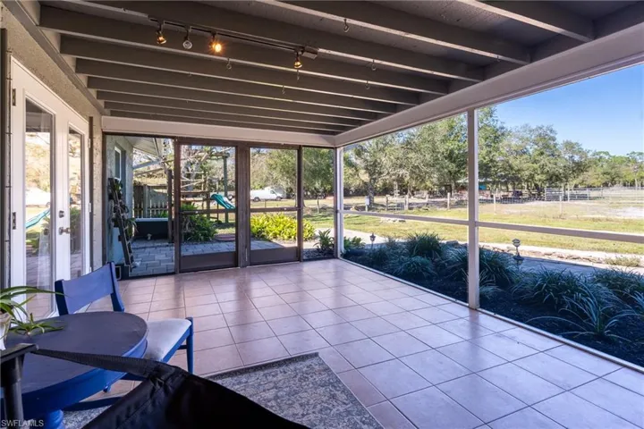 Unfurnished sunroom featuring track lighting and beam ceiling