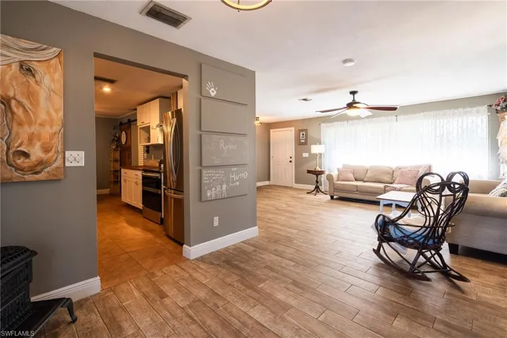 Living room with light hardwood / wood-style flooring and ceiling fan