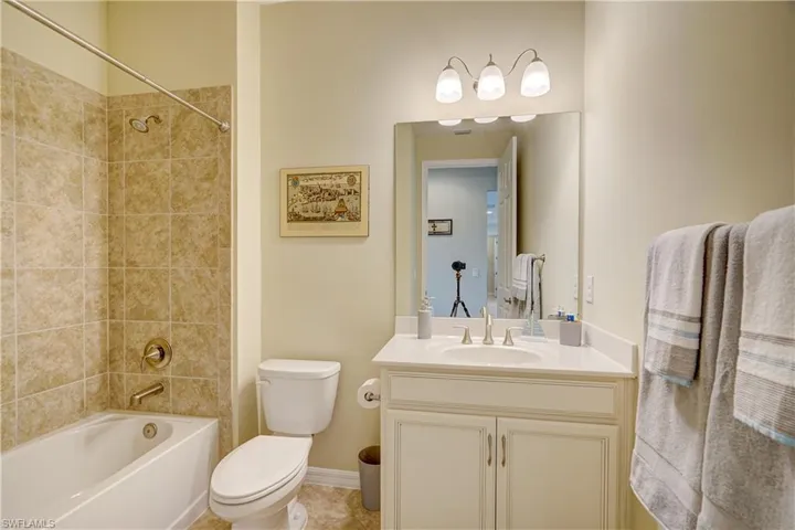 Bathroom #2 with tiled shower/tub combo, and vanity with quartz countertop