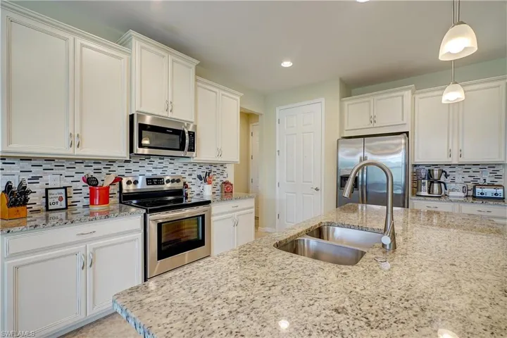 Granite countertops, beautiful backsplash, and white cabinets give that SW Florida feel