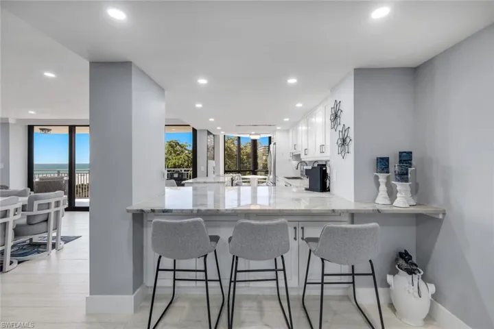 The property features a kitchen with white cabinetry and a light-colored countertop, complemented by recessed lighting