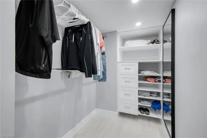 Custom closet with built-in shelving, drawers, and hanging rods