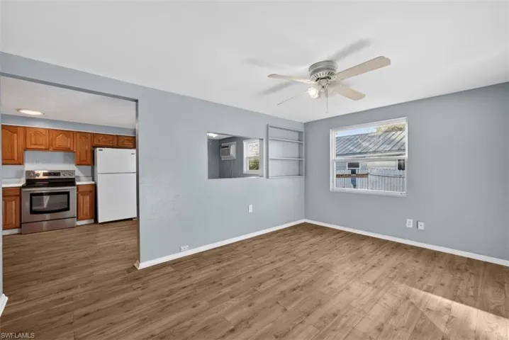 Unfurnished living room featuring light wood-style floors, ceiling fan, and built in shelves