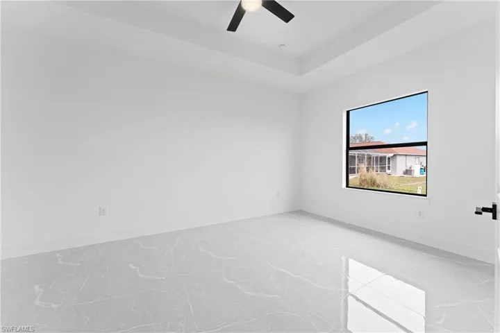 Spare room featuring a tray ceiling and ceiling fan