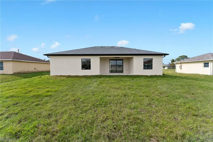 Rear view of property with a lawn