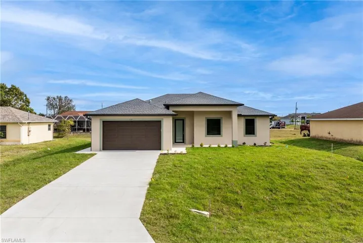 View of front facade featuring a garage and a front yard