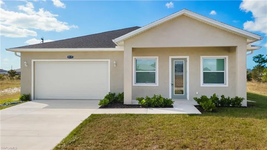 Single story home featuring a porch, stucco siding, driveway, and a front lawn