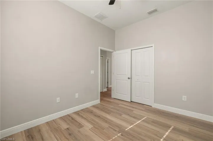 Unfurnished bedroom with light wood finished floors, a closet, and ceiling fan