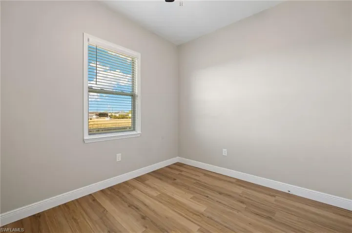 Empty room featuring baseboards and wood finished floors