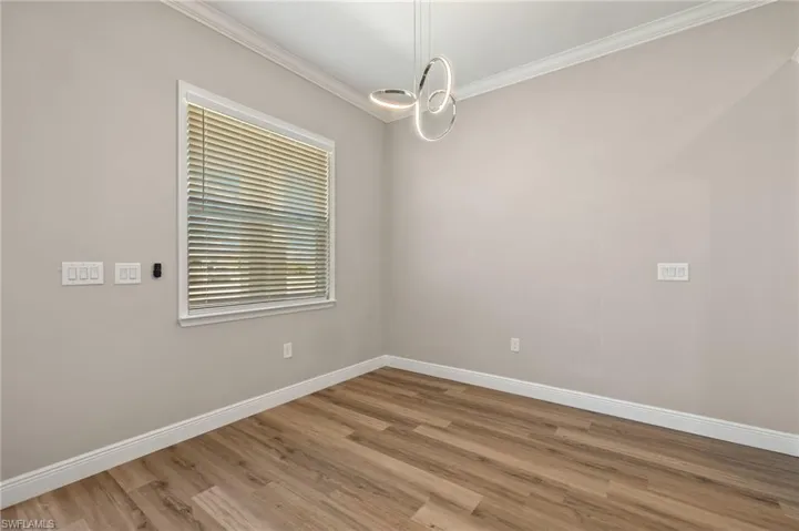 Empty room with wood finished floors and crown molding