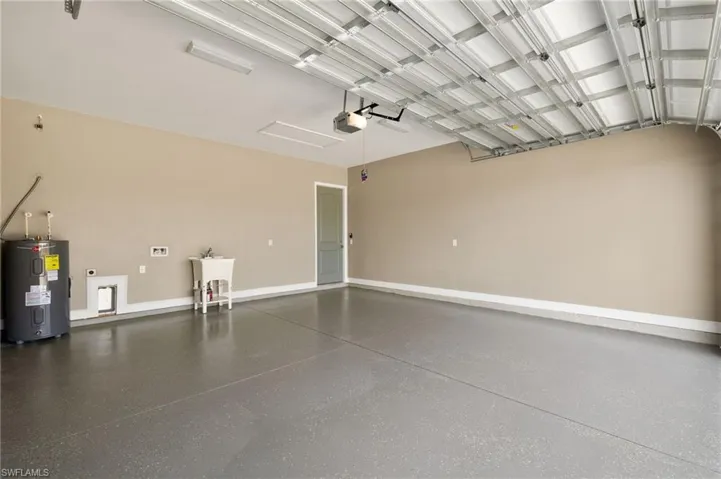Garage featuring water heater and a garage door opener
