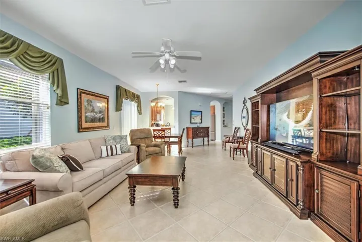 Another view of tiled living room with ceiling fan!