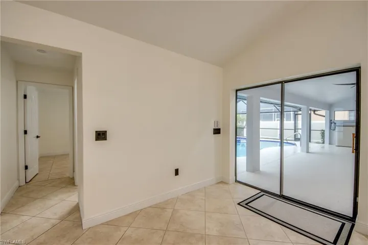 Tiled spare room with vaulted ceiling