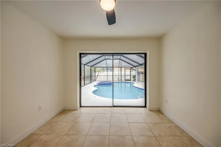 Empty room with light tile flooring and ceiling fan