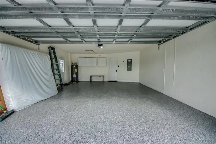 Garage featuring water heater and a garage door opener