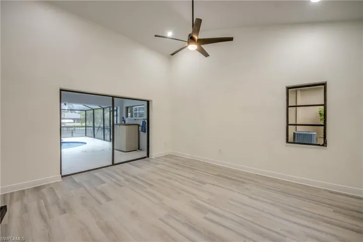 Unfurnished room featuring high vaulted ceiling, ceiling fan, and light wood-type flooring