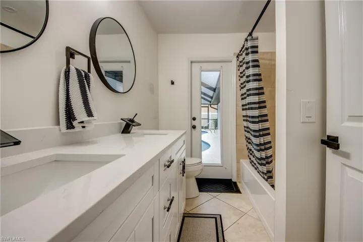 Full bathroom featuring tile flooring, shower / bath combo, vanity, and toilet